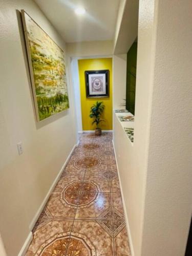 a hallway with yellow walls and a tile floor at Desert Sun Flower: Private Spa, pool, Golf area in Coachella