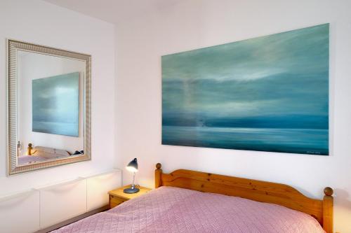 ein Schlafzimmer mit einem Bett und einem großen Gemälde an der Wand in der Unterkunft Ferienwohnung 'alte Schule' in Nienhagen
