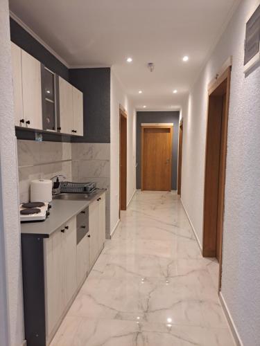 Elshani的住宿－Vila Kikeski，厨房配有白色橱柜和瓷砖地板。