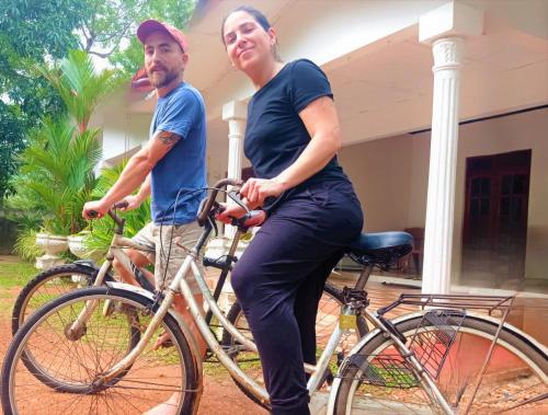 a man and a woman sitting on a bike at Grand Refuge wilpathu safari Home made foods Bikes Bicycles Tuk tuk Bird view Lake jogging in Anuradhapura