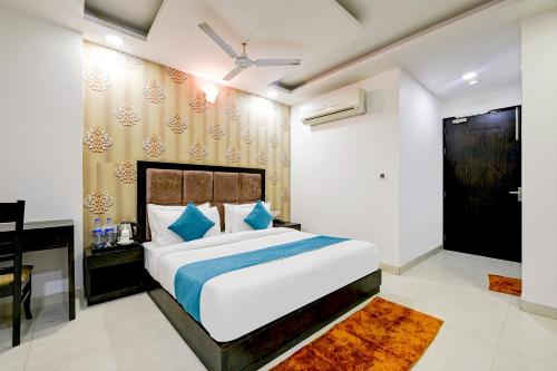 ocaen Suites Near Delhi Airport في نيودلهي: غرفة نوم مع سرير أبيض كبير ومكتب