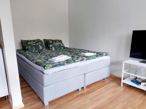 małe łóżko w pokoju z telewizorem w obiekcie Spacious studio apartment near the center of Joensuu w mieście Joensuu