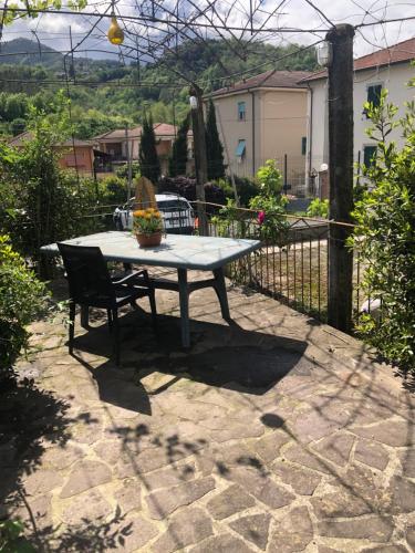 a table and a chair on a stone patio at La Primula Vicinanza 5 Terre in Riccò del Golfo di Spezia