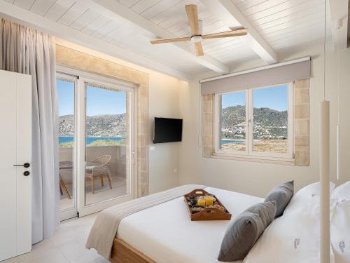 a bedroom with a bed and a view of the ocean at Pietra Di Sabbia Villas in Palaiochóra