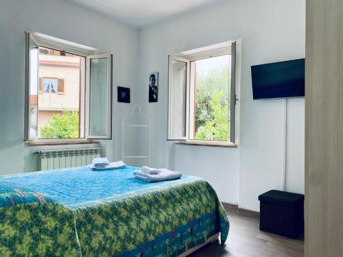 a bedroom with a bed and two windows at Casa Leonardo in Castiglione della Pescaia