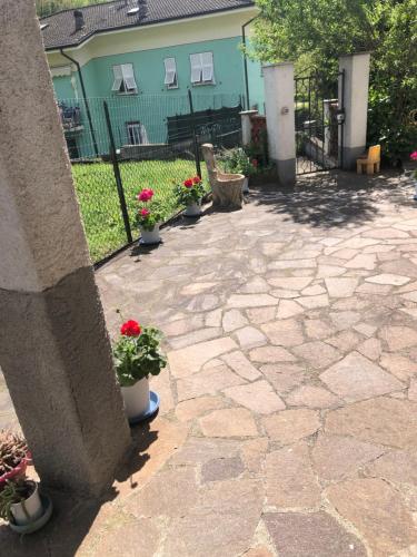 a stone patio with potted plants and a fence at La Primula Vicinanza 5 Terre in Riccò del Golfo di Spezia