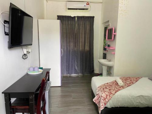 a room with a bed and a bathroom with a television at Padang Besar Green Inn in Padang Besar