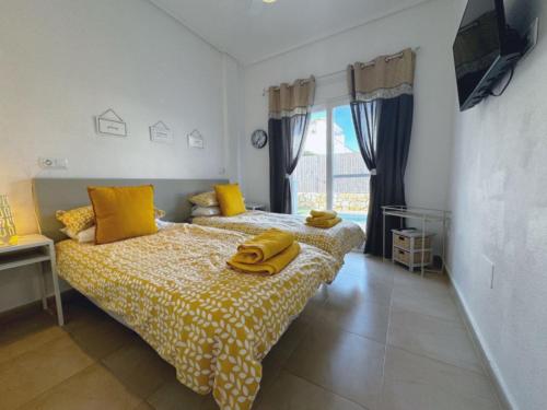 Un dormitorio con una cama con almohadas amarillas. en Calle Lubina 59, en Roldán