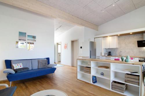 a living room with a blue couch and a kitchen at Ferienwohnungen Walz in Pfullendorf