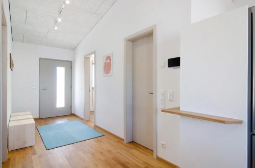an empty room with a blue rug on a wooden floor at Ferienwohnungen Walz in Pfullendorf
