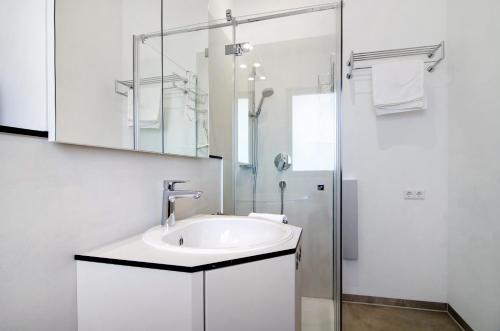 a white bathroom with a sink and a shower at Ferienwohnungen Walz in Pfullendorf
