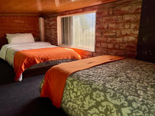 2 Betten in einem Zimmer mit Fenster in der Unterkunft Sinestesia House in Baños