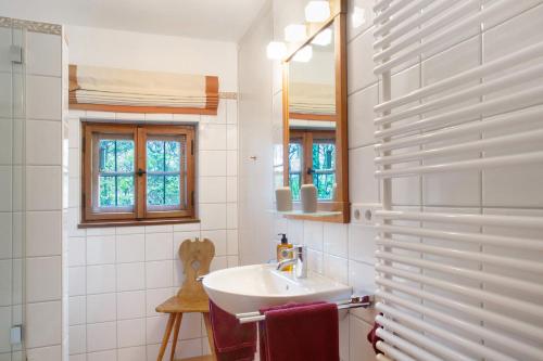 Baño blanco con lavabo y espejo en Ferienhaus Auszeithaus, 