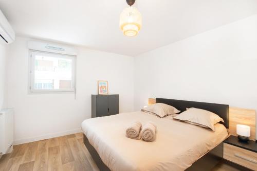 une chambre avec un lit avec deux pantoufles dessus dans l'établissement BOUIN - Frontière Monaco - Luxueux 2 pièces refait à neuf, à Beausoleil