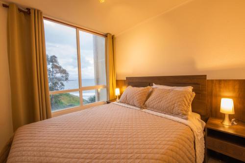 1 dormitorio con cama y ventana grande en Oceana Suites en Costa Quilen, vistas al mar, en Puchuncaví