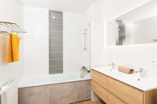 y baño con bañera, lavabo y espejo. en BOUIN - Frontière Monaco - Luxueux 2 pièces refait à neuf en Beausoleil