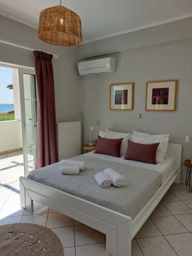 a bedroom with a large bed with towels on it at The Three Palms Samos Seaside Villa in Mesókampos