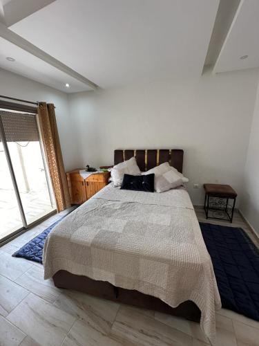 um quarto com uma cama grande e uma janela grande em Kenitra em Kenitra