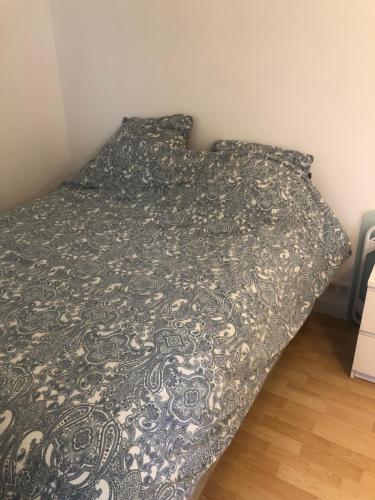 - un lit avec une couverture noire et blanche dans l'établissement Beautiful and quiet 1 bedroom 10min from Paris, à Colombes