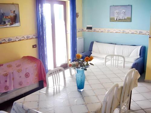 ein Zimmer mit einem Tisch mit einer Vase mit Blumen darauf in der Unterkunft One bedroom house with sea view and enclosed garden at Casal Velino 6 km away from the beach in Casal Velino