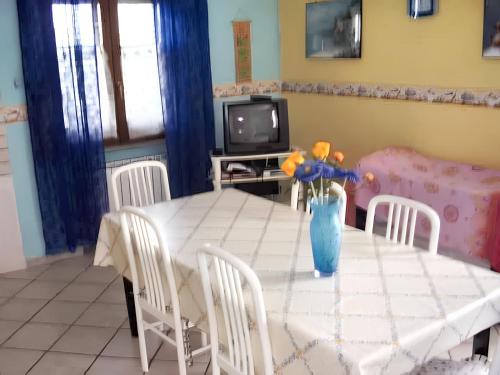 ein Esszimmer mit einem Tisch und einer Vase aus Blumen in der Unterkunft One bedroom house with sea view and enclosed garden at Casal Velino 6 km away from the beach in Casal Velino