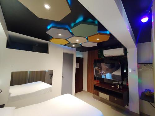a room with a bed and a tv on a ceiling at Hospedaje Diamantes in Huacho