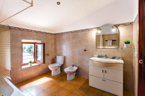 a bathroom with a sink and a toilet and a window at Ses Angoixes in Santanyi