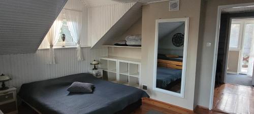 Cudodomek na Mazurach w Woszczelach koło Ełku في إوك: غرفة بسرير ودرج مع مرآة