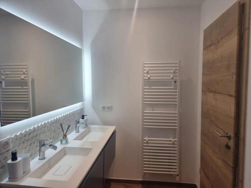 - une salle de bains blanche avec deux lavabos et un miroir dans l'établissement Le Chalet de Maeva * 10 pers * jacuzzi, à Xonrupt-Longemer