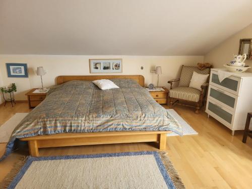 1 dormitorio con 1 cama grande y 1 silla en Ferienwohnung Salzburgblick, en Bad Reichenhall