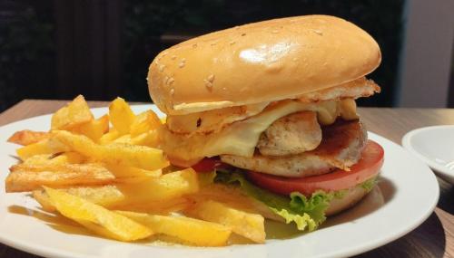 a plate with a chicken sandwich and french fries at Hospedaje Diamantes in Huacho