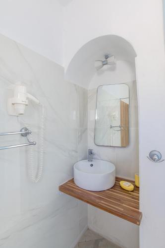 a white bathroom with a sink and a mirror at Glyfa Village in Drios