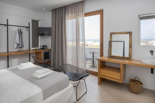 een slaapkamer met een bed, een wastafel en een spiegel bij Basilico Suites Adults Only in Gouves