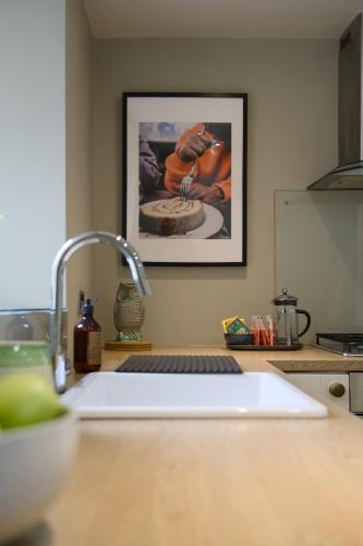 a kitchen counter with a sink and a picture on the wall at The Beeches - Chatsworth Apartment No 3 - Sleeps 2 in Baslow