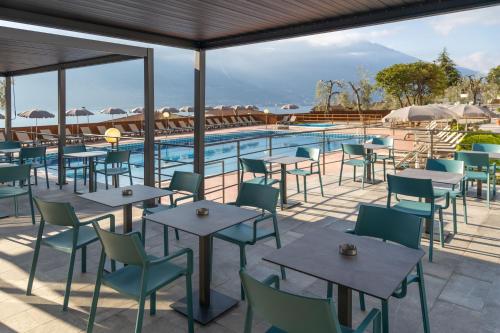 um restaurante com mesas e cadeiras ao lado de uma piscina em Aria Life Hotel em Limone sul Garda