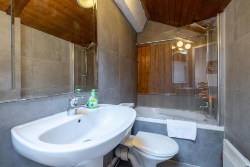 een badkamer met een wastafel, een toilet en een bad bij Skyhook: Batiment B in Chamonix-Mont-Blanc