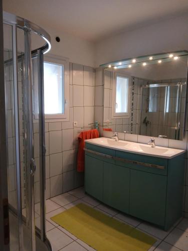 uma casa de banho com uma banheira, um lavatório e um espelho. em Maison sanguinet à 100m du lac em Sanguinet