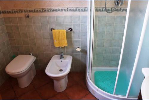 een badkamer met een toilet, een douche en een wastafel bij VILLA CATERINA in Calasetta