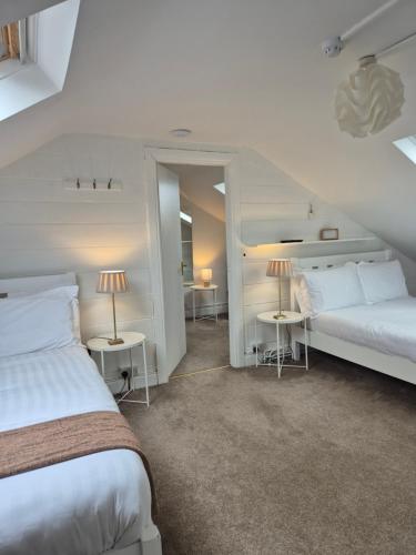 1 dormitorio con 2 camas y 2 mesas con lámparas en The Old Exchange, en Clifden
