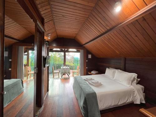 um quarto com uma cama e um sofá num quarto em Reserva Santo Antônio em Santo Antônio do Pinhal
