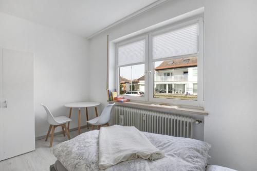een slaapkamer met een bed, een tafel en een raam bij Ferienwohnung in Günzburg