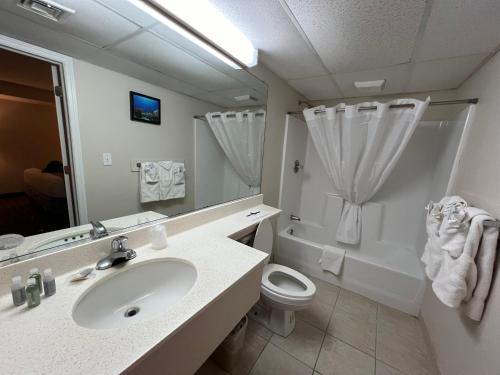 Un baño con lavabo, inodoro y ducha. en El Coronado Resort, en Wildwood Crest