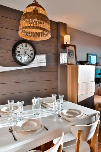 une salle à manger avec une table blanche et une horloge dans l'établissement IMMODREAMS - Le Choucas - Avoriaz, à Avoriaz