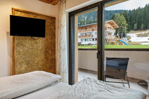 a bedroom with a window with a view of a mountain at Blosegghof Bergchalets Waldblick in Racines