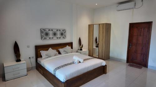Turtle House Lombok في كوتا لومبوك: غرفة نوم بسرير كبير مع شراشف بيضاء