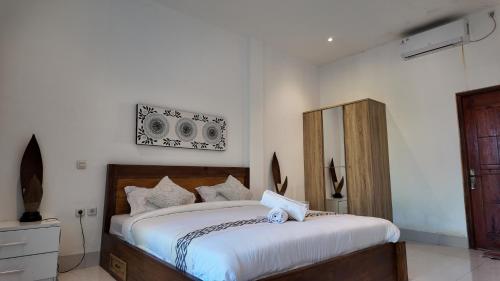 a bedroom with a large bed with white sheets at Turtle House Lombok in Kuta Lombok