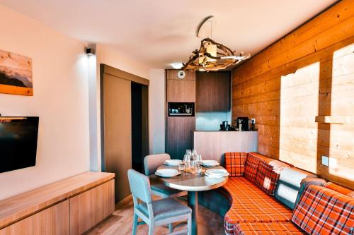 a dining room with a table and a couch at IMMODREAMS - L'Igloo - Avoriaz in Avoriaz