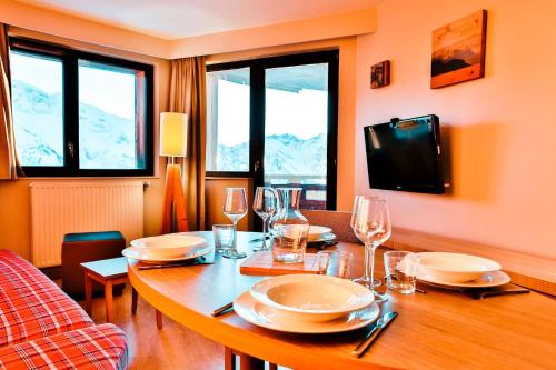 a dining room with a table with plates and wine glasses at IMMODREAMS - L'Igloo - Avoriaz in Avoriaz