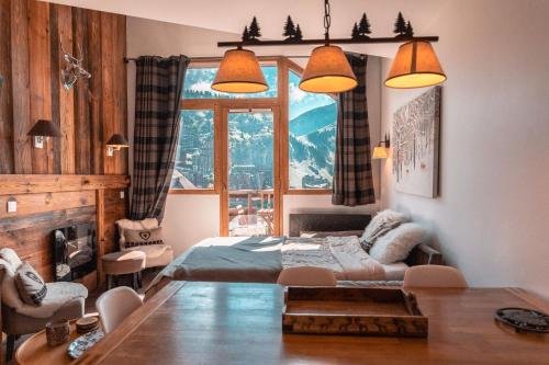 une chambre avec un lit et une grande fenêtre dans l'établissement IMMODREAMS - La Marmotte - Avoriaz, à Avoriaz