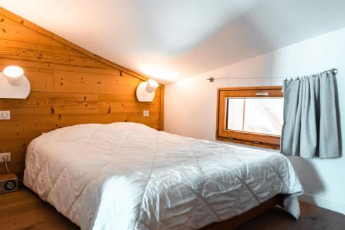 a bedroom with a bed with a wooden wall at IMMODREAMS - Le Chalet - Avoriaz in Avoriaz